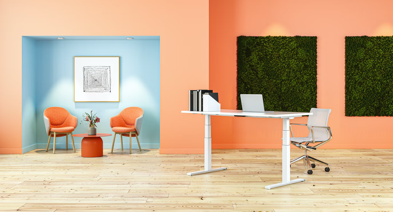 パステルピンク色の壁面に、グリーンのパネルとパステルの水色の個室があるオフィス空間の写真